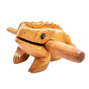 Guiro en bois en forme de grenouille, avec sa baguette glissée entre les mâchoires, vu de face