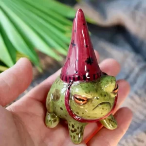 Figurine de grenouille verte mouchetée au chapeau rouge pointu, vue rapprochée