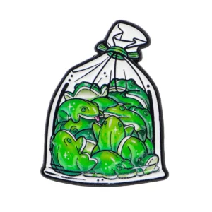 Broche figurant plusieurs grenouilles vertes réunies dans un sachet blanc noué, vue de face