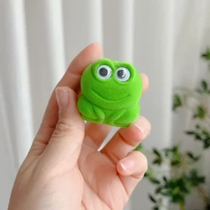 Boîte à bague verte en forme de grenouille, fermée et tenue dans une main