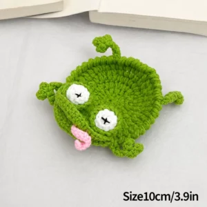 Sous-verre crocheté vert en forme de grenouille, yeux blancs et langue rose