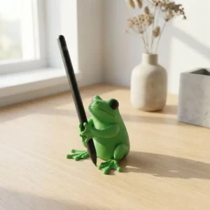 Grenouille verte porte-stylo tenant un stylo noir