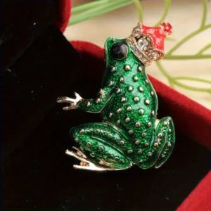 Broche grenouille assise et couronnée sur fond sombre