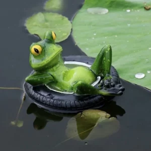 Grenouille verte allongée dans une bouée noire sur l’eau près de nénuphars
