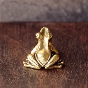 Petite grenouille en laiton assise, photographiée de dos