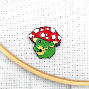 Garde-aiguilles magnétique grenouille jouant de la guitare sous un champignon rouge